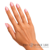 Manucure rose pastel délicatement scintillante avec le vernis 1944 Paris Ivana sur ongles ovales et peau claire.