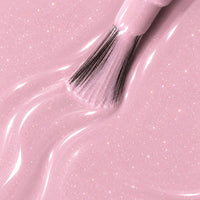 Texture du vernis semi-permanent vegan 1944 Paris Ivana, rose pastel aux micro-paillettes scintillantes, avec pinceau applicateur.