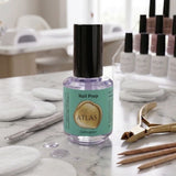 Flacon de Nail Prep ATLAS 15ml, présenté sur une table de travail en marbre aux côtés de cotons et outils professionnels.