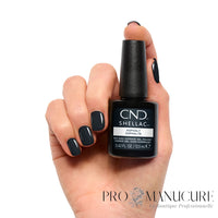 Manucure gris anthracite profond réalisée avec CND Shellac Asphalt, flacon présenté dans la main